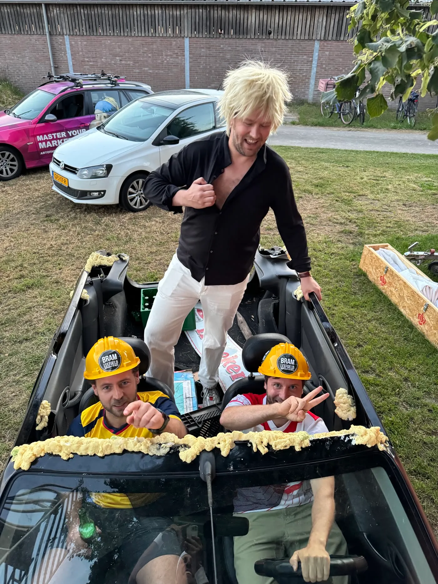 Bram Leefgeld op een auto met twee Helmhout-helmen